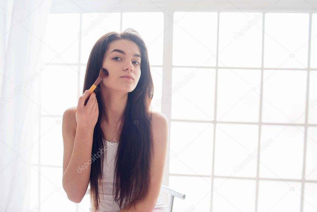 El cuidado de la piel para una mujer joven y un maquillaje de la mañana