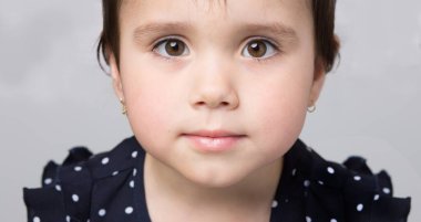 Kahverengi saçlı küçük güzel bir kızın yakın plan portresi.