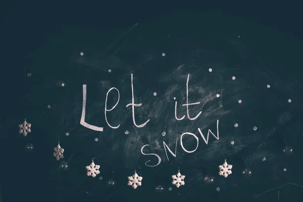 Låt det snö text på mörk bakgrund med snöflingor prydnad. — Stockfoto