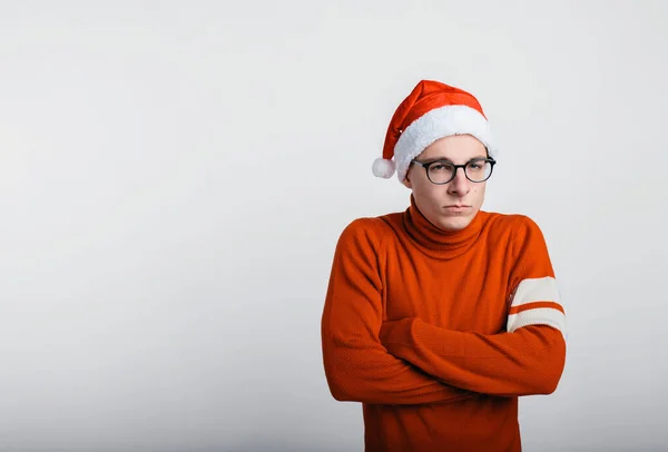 Nieszcześliwy yong człowiek w świątecznym kapeluszu odizolowany na białym. — Zdjęcie stockowe