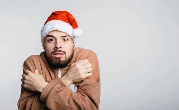 Portret van de man gekleed in een pyjama i Kerst rode hoed in koude geïsoleerde — Stockfoto