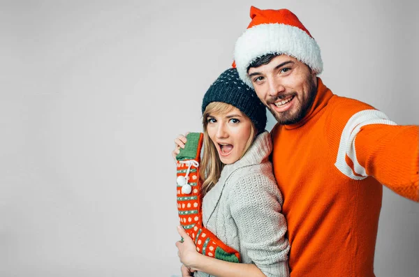 Junger bärtiger Mann isoliert über Hintergrund. Emotiona Mann und Frau machen Selfie. Seitenansicht einer jungen Familie in festlicher Kleidung mit weihnachtlicher Kleidung. Positiv glückliche Menschen auf dem Bild. — Stockfoto