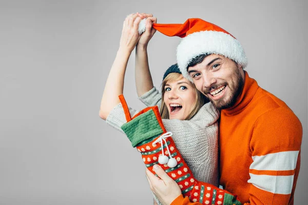 Junger bärtiger Mann und fröhliche Frau isoliert über dem Hintergrund. Lustige Menschen in roter Weihnachtskleidung. Lustige junge Familie posiert vor der Kamera. Neujahr oder Weihnachten. — Stockfoto