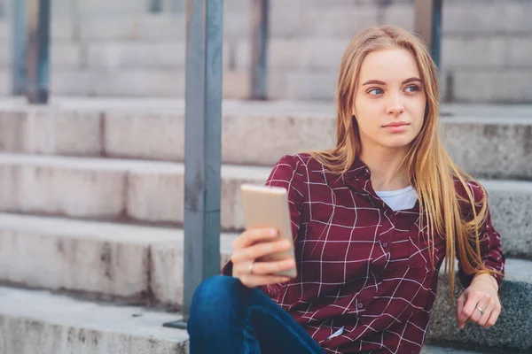 Dziewczyna siedzi na schodach i rozmawia przez telefon. — Zdjęcie stockowe