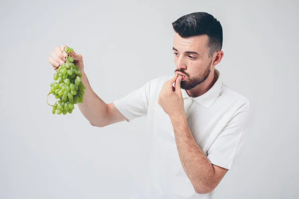 Mann mit Trauben in der Hand, aus nächster Nähe. Konzept. isoliert auf weiß — Stockfoto