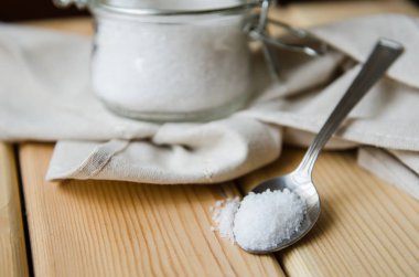 Beyaz Deniz tuzlu beyaz peçete üzerinde bir demir kaşık kavanoz içinde