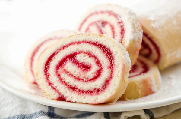 Färsk söt rulle med jordgubbssylt och strösocker på en tallrik och vit handduk — Stockfoto