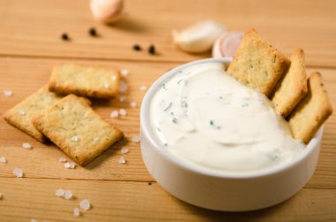 Biberli tuzlu atıştırmalıklar, beyaz sos tuz yeşillik. Ahşap masa