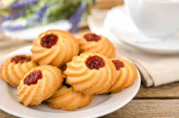 Kekse mit Marmelade auf Holztisch mit einem Becher Tee — Stockfoto