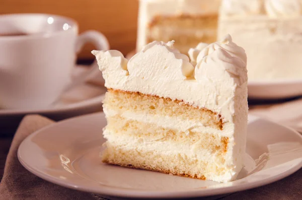 Un morceau de gâteau avec de la crème blanche sucrée sur l'assiette. Filtre Instagram, tonifiant — Photo
