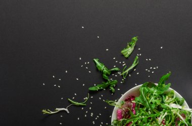 Rucola ve marul kase siyah bir zemin üzerine yeşil salata. Üstten Görünüm, vejetaryen, diyet yemek