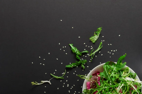 Rucola ve marul kase siyah bir zemin üzerine yeşil salata. Üstten Görünüm, vejetaryen, diyet yemek