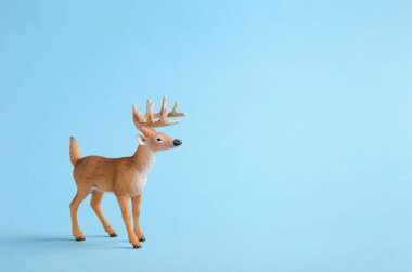 Mavi arka planda oyuncak geyik. Çocuklar için arka plan ya da kış reklam afişi. Boşluğu kopyala