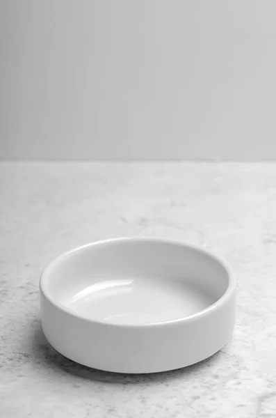Чиста маленька біла тарілка на фоні світлого каменю. Мінімалістична кухня, посуд. Копіювати простір . — стокове фото
