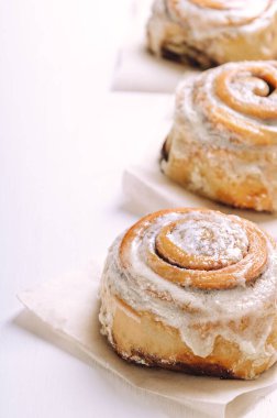 Beyaz arka planda kremalı tarçınlı çörekler. Tatlı hamur işleri. Boşluğu kopyala.