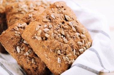 Sepetteki havlunun üzerinde ayçiçeği tohumları olan ekmek. Sağlıklı yemek, köy tarzı.