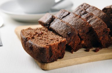 Tahta bir masada dilimlenmiş çikolatalı kek. Kahvaltıda tatlı hamur işleri.