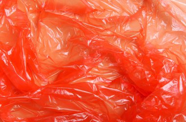Kırmızı naylon, paket, polipropilen, bej arka planda plastik ambalaj. Plastik kirliliği kavramı. Üst görünüm, düz görünüm, doku