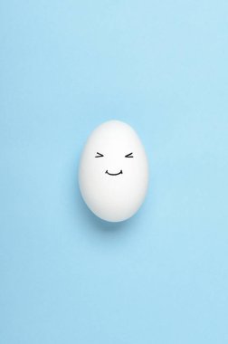 Kawaii mavi arka planda beyaz yumurtalara bakıyor. Çizgi filmler, çocuklar için dekorasyon yemekleri. Üst manzara, düz uzanma