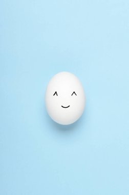 Kawaii mavi arka planda beyaz yumurtalara bakıyor. Çizgi filmler, çocuklar için dekorasyon yemekleri. Üst manzara, düz uzanma