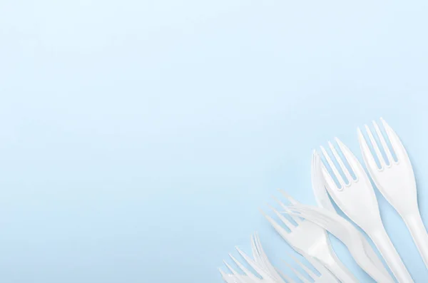 Πλαστικά Λευκά Πιρούνια Μιας Χρήσης Και Μαχαίρια Μπλε Φόντο Έννοια — Φωτογραφία Αρχείου