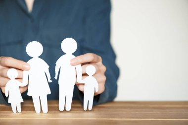 Ayrıl ve boşan. Aile kavramında ilişki bozulması. Karı koca ayrılıyoruz. Yırtık kağıt insan figürlerini tutan kadın elleri. Boş kopyalama alanı.