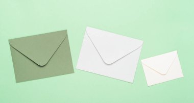 Yeşil arka planda yeşil ve beyaz zarflar. Harflerin, mesajların, yazışmaların konsepti, kopyalama alanı, üst görünüm, düz yatış