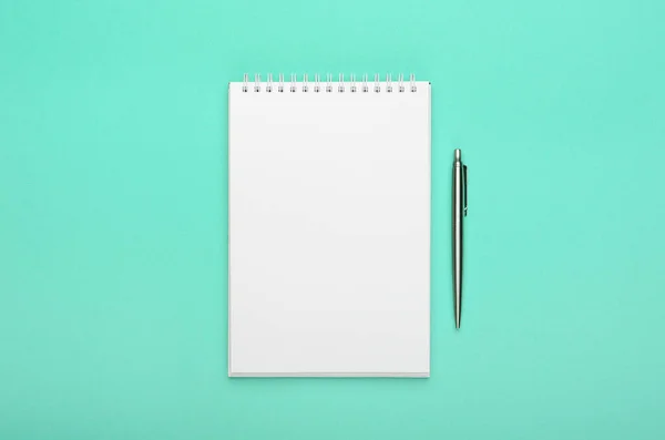蓝绿色背景上有钢笔的白色记事本 写字台 最小的构图 复制空间 — 图库照片