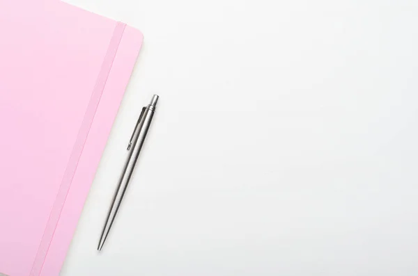 用钢笔写在白色木制背景上的粉红笔记本 最小的构图 节省空间 顶部视图 平面布局 — 图库照片