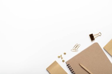 Beyaz arka planda kurşun kalem, düğme, çıkartma, kırtasiye kağıdı olan el işi defterler. Ofis masası, ofis malzemeleri. Boşluğu kopyala, üst görünüm, düz uzanma