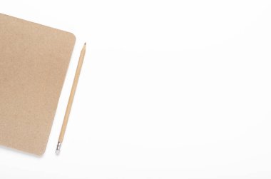 Beyaz arka planda kurşun kalemle yazılmış Kraft kağıt defteri. Ofis masası, kırtasiye. Boşluğu kopyala, üst görünüm, düz uzanma