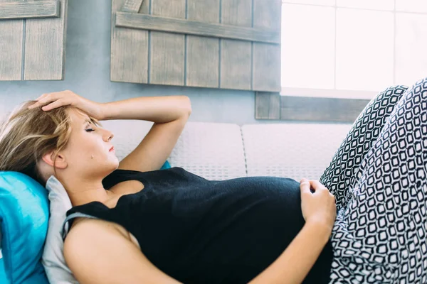 Mujer embarazada en el sofá — Foto de Stock