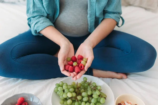 Mulher grávida comendo uvas — Fotografia de Stock