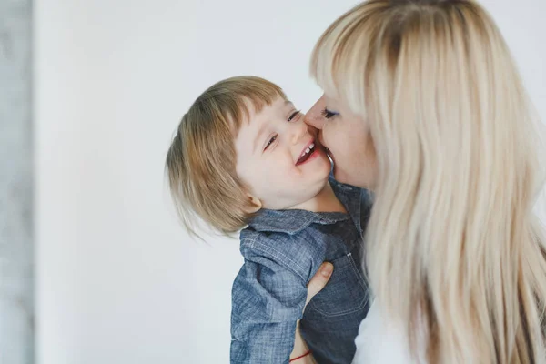 mother kissing little boy