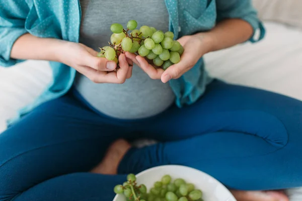 Zwangere vrouw eten druiven — Stockfoto