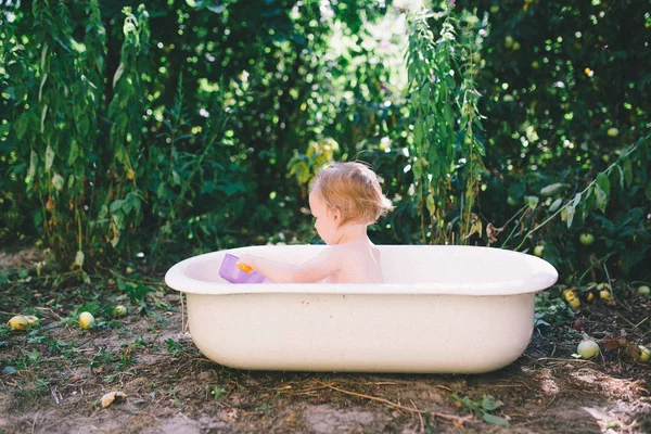 Маленькая девочка купается в детской ванне — стоковое фото