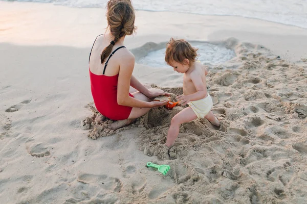 Bebê menina e mãe na praia do mar — Fotografia de Stock