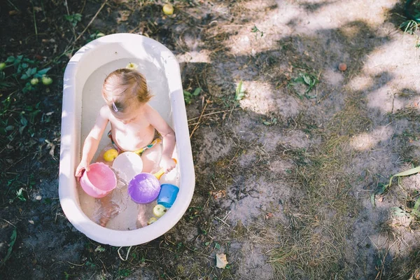 Маленькая девочка купается в детской ванне — стоковое фото