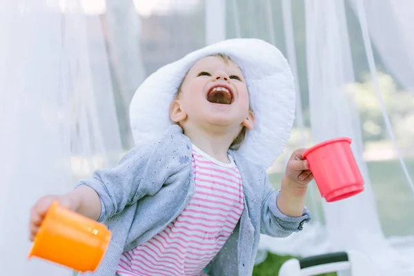 Маленька дівчинка грає з чашками — стокове фото