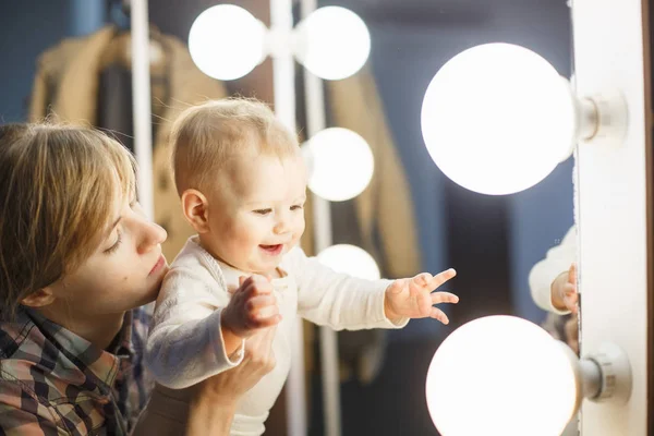 Baby looking at lights and mother — Stock Photo, Image