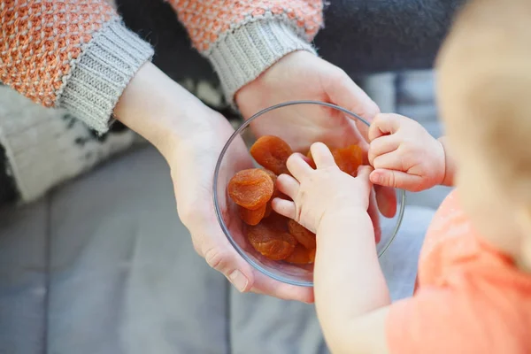 Mother giving dry apricots to baby — Stock Photo, Image