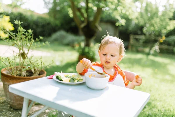 Девочка ест пюре — стоковое фото