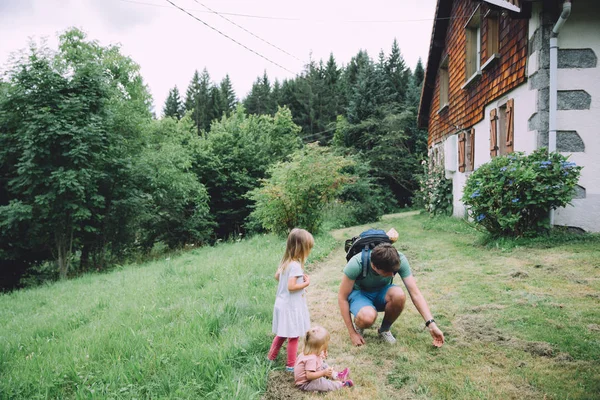 Отец играет с маленькими дочерьми на открытом воздухе — стоковое фото