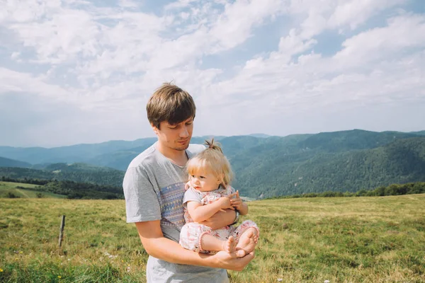 Bebé niña y padre contra montañas verdes — Foto de Stock