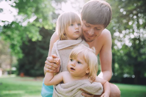 Padre con hijas pequeñas en el jardín — Foto de Stock