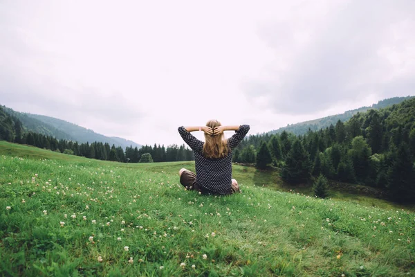 Jeune femme assise sur l'herbe — Photo