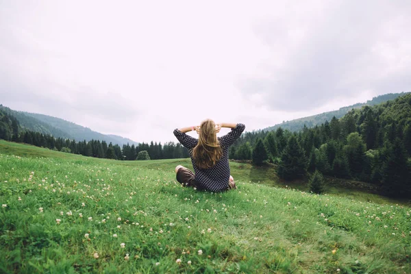 Jeune femme assise sur l'herbe — Photo