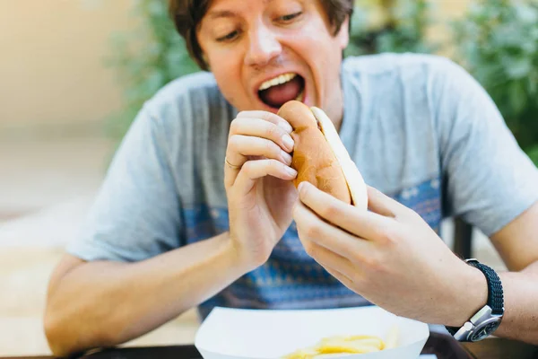 Homme manger hotdog — Photo