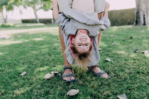 Man holding girl upside down — Stock Photo, Image