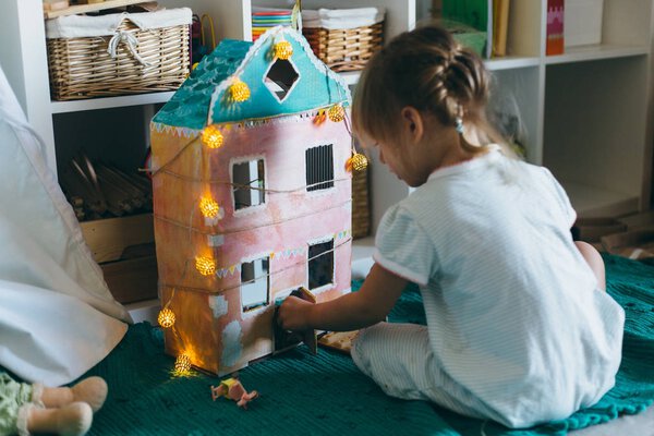 Little girl playing with toy house — Stock Photo, Image